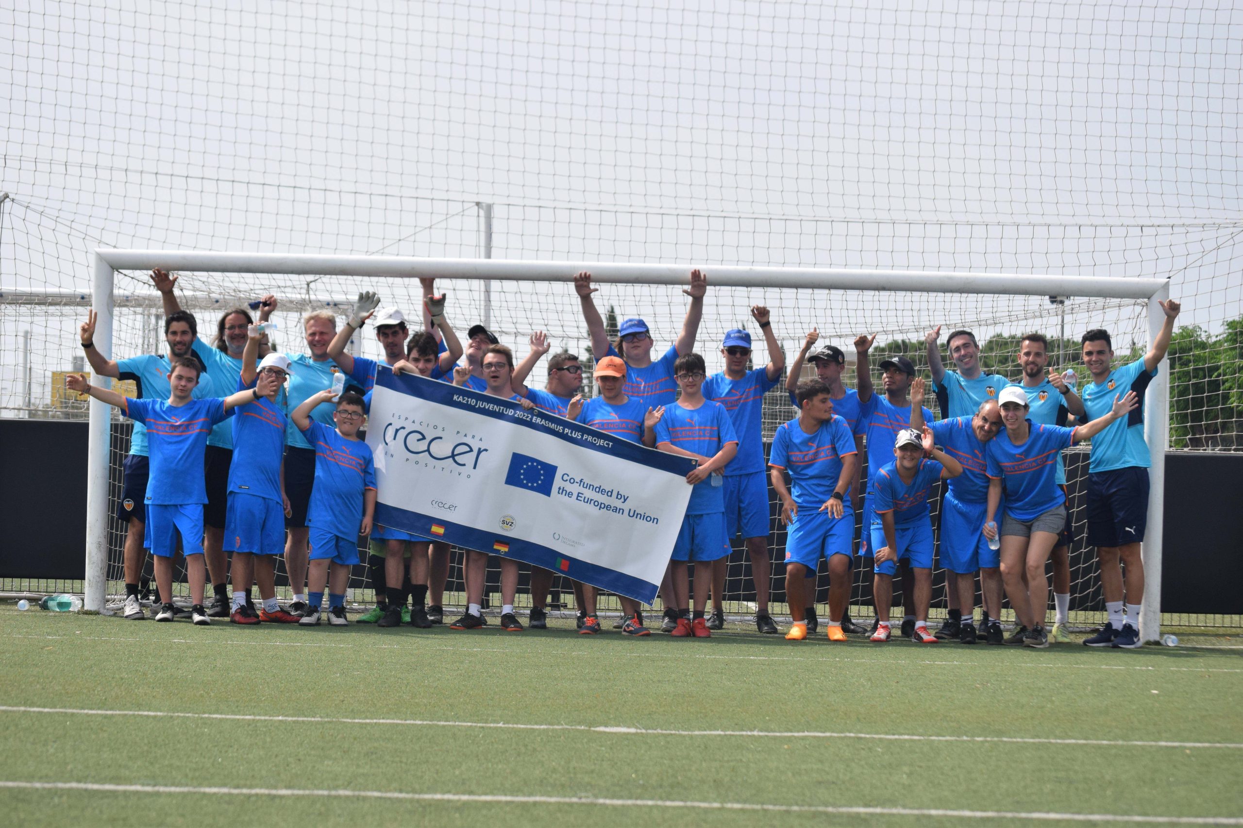 Crecer en Positivo Summer Football Clinic Football Team, pictured in front of a 11 a side football goal, together with project partners teams
